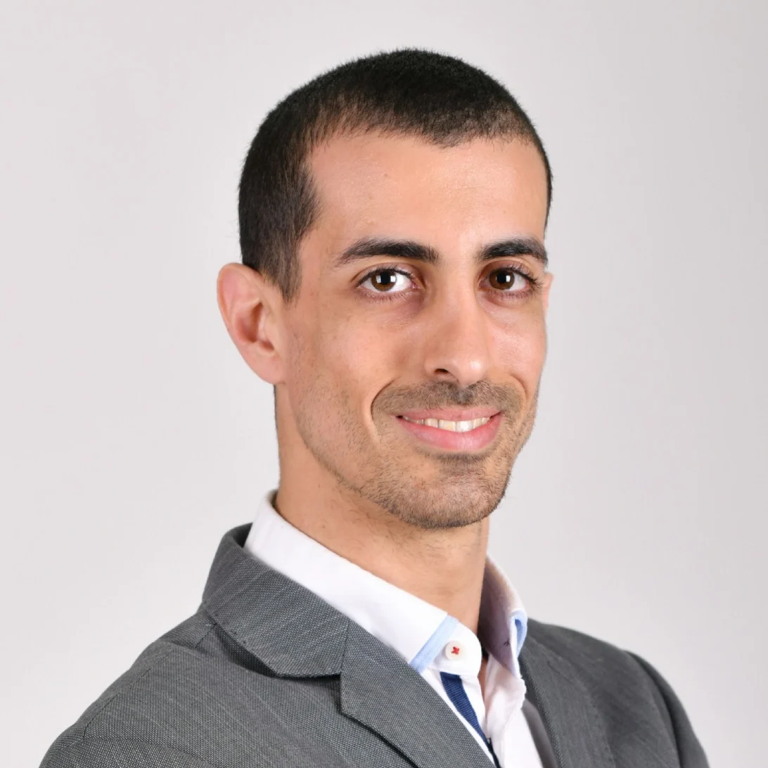 Smiling person in a gray suit.